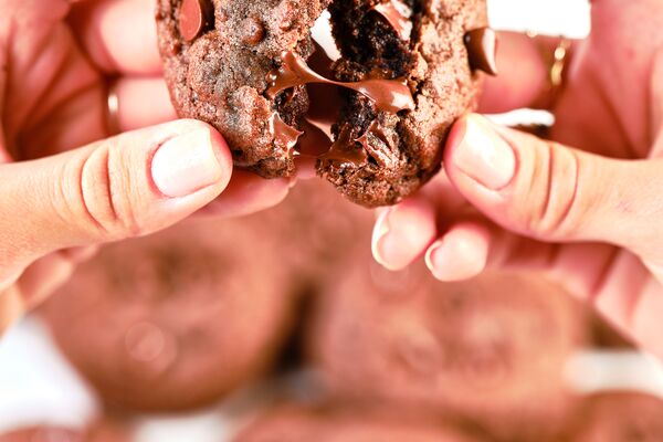 hands pulling apart a double chocolate chip cookie
